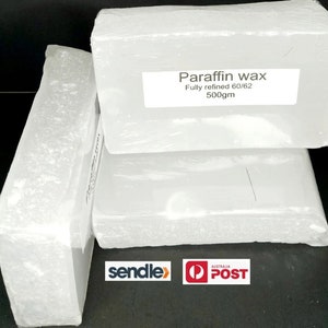 Puede incluir: Tres bloques blancos de cera de parafina, cada uno envuelto en pl&aacute;stico transparente. El bloque superior tiene una etiqueta que dice "Paraffin wax Fully refined 60/62 500gm".