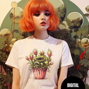 May include: White t-shirt with a graphic print of a carnivorous plant with multiple mouths in a pink pot. The plant is green with red and white accents. The text "DIGITAL DOWNLOAD" is on a black circle.