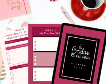 May include: A pink and white planner with the text "the Creative Business PLANNER 2022" on the cover. The planner has a section for "Week 2: My Creative Skills" and "Week 3: Product Ideas from core skills, ideas & know-how".