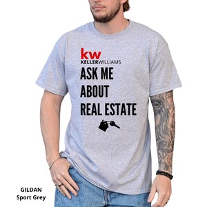 May include: A light gray Gildan Sport Grey t-shirt with the Keller Williams logo and the text "ASK ME ABOUT REAL ESTATE" in black. A small graphic of a house and key is below the text.
