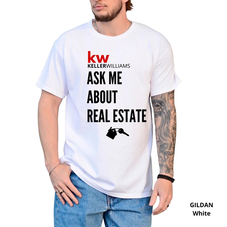 May include: White t-shirt with the text "ASK ME ABOUT REAL ESTATE" in black, below the "kw KELLERWILLIAMS" logo in red and black. A graphic of a house and key is below the text. The shirt is a Gildan White.