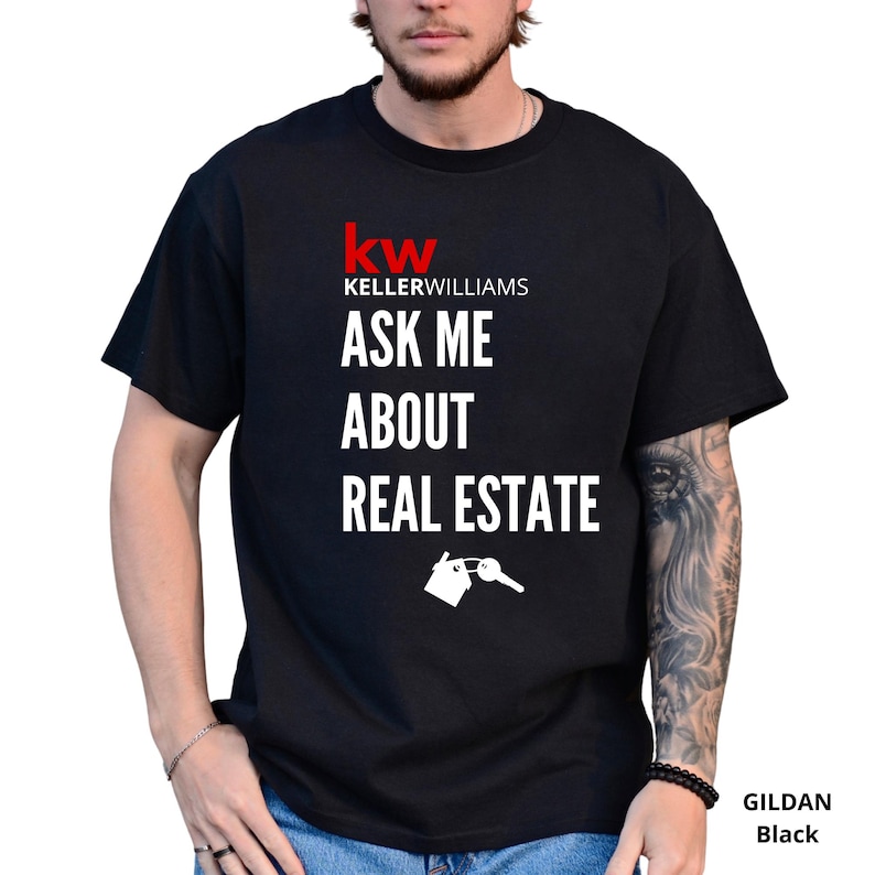 May include: Black t-shirt with the Keller Williams logo in red and white. The text "ASK ME ABOUT REAL ESTATE" is printed below the logo, along with a graphic of a house and key.