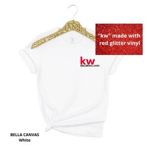 May include: A white Bella Canvas t-shirt hanging on a gold glitter hanger. The shirt features a red glitter vinyl 'kw' logo above the black text 'KELLERWILLIAMS' on the left chest. A small inset shows the red glitter texture of the 'kw' logo.