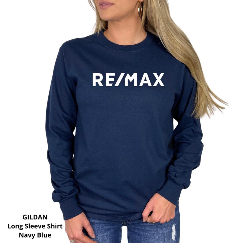 May include: Navy blue long-sleeve shirt with the white text "RE/MAX" across the chest. The shirt is a Gildan long sleeve shirt.