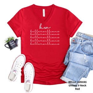 May include: A red Bella Canvas unisex V-neck t-shirt with the text "kw kellerwilliams" in white. The image also includes a pair of white sneakers, blue jeans, and a small black decorative pot with the words "Sweet Home".