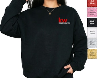 May include: A black long-sleeve sweatshirt featuring the red and white text 'kw KELLERWILLIAMS' on the upper left chest. To the right, a vertical color chart displays glitter options labeled Red, Pink, Black, White, Silver, and Gold.