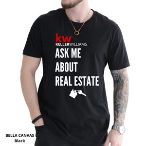 May include: Black t-shirt with the text "ASK ME ABOUT REAL ESTATE" in white. The Keller Williams logo is at the top, with a house and key graphic below the text. The shirt is a Bella Canvas brand.
