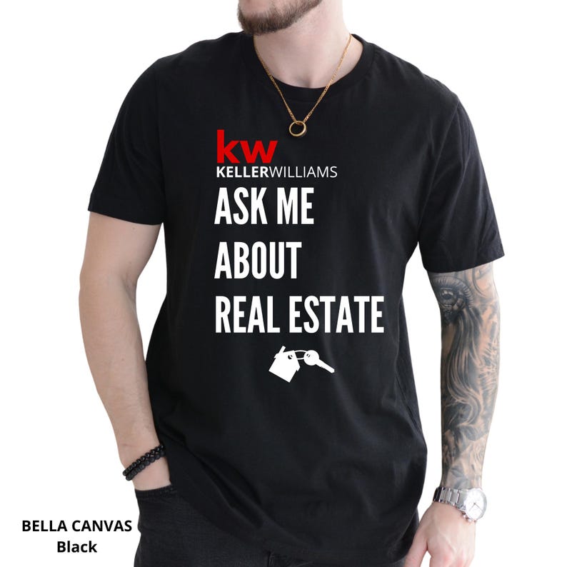 May include: Black t-shirt with the text "ASK ME ABOUT REAL ESTATE" in white. The Keller Williams logo is at the top, with a house and key graphic below the text. The shirt is a Bella Canvas brand.
