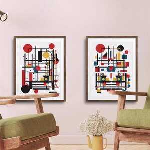 K&ouml;nnte beinhalten: Zwei gerahmte Wandkunstdrucke mit abstrakten geometrischen Kompositionen. Jeder Druck zeigt einen wei&szlig;en Hintergrund mit einer strukturierten Anordnung aus schwarzen Linien, roten Kreisen, gelben Rechtecken und blauen Quadraten.