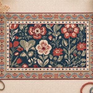 May include: A finished cross-stitch floral design with red and white flowers, green leaves, and a dark blue backdrop. The design is framed with a decorative border in shades of red, blue, and beige. Scissors and thread are visible.