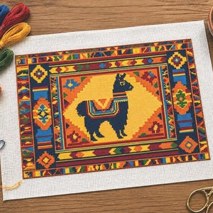 Può includere: Un colorato progetto a punto croce con un design a forma di lama. La lama è blu scuro con una sella fantasia, su uno sfondo giallo. Il bordo è un mix di motivi geometrici arancioni, blu e rossi. Fili da ricamo e forbici sono vicini.