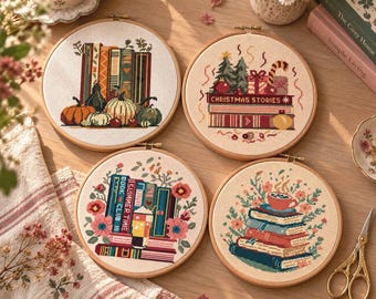 May include: Four circular embroidery hoops featuring cross-stitch designs on fabric. One shows pumpkins and books, one displays Christmas Stories with gifts, one depicts Summer Time Book Club with flowers, and one shows a stack of books with a tea cup.