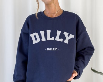 May include: A navy blue sweatshirt with the text "DILLY -DALLY- " in white.