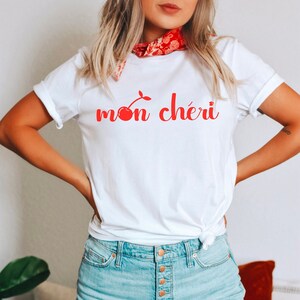 May include: White t-shirt with a red cherry graphic and the text "mon ch&eacute;ri" in red.