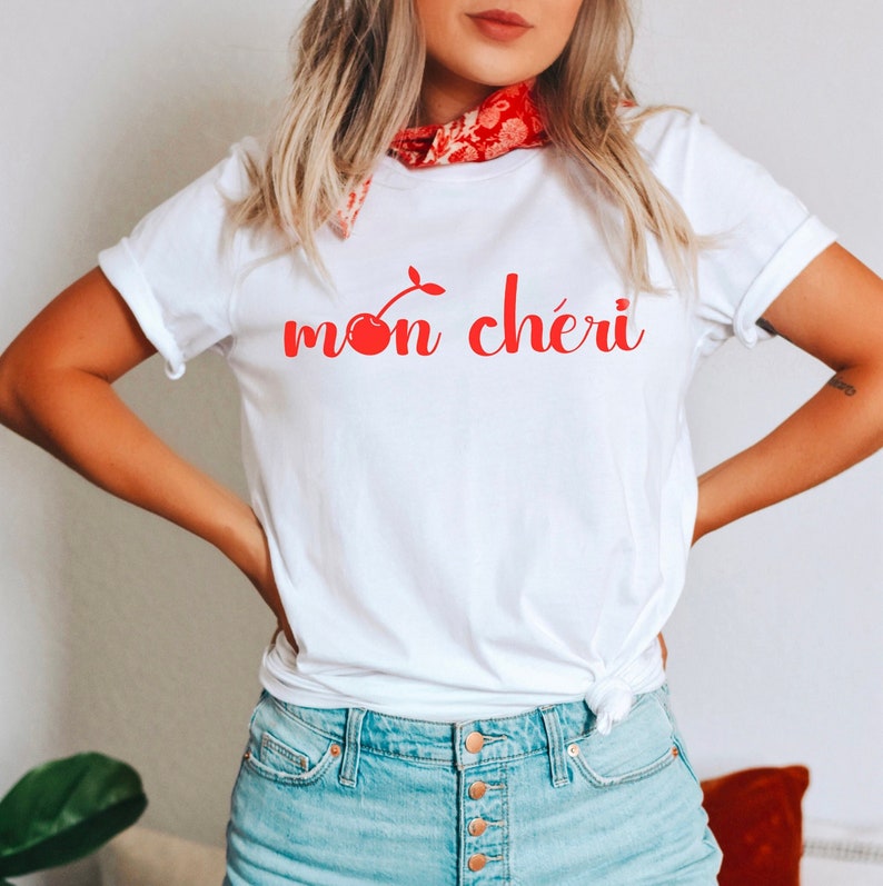May include: White t-shirt with a red cherry graphic and the text "mon ch&eacute;ri" in red.