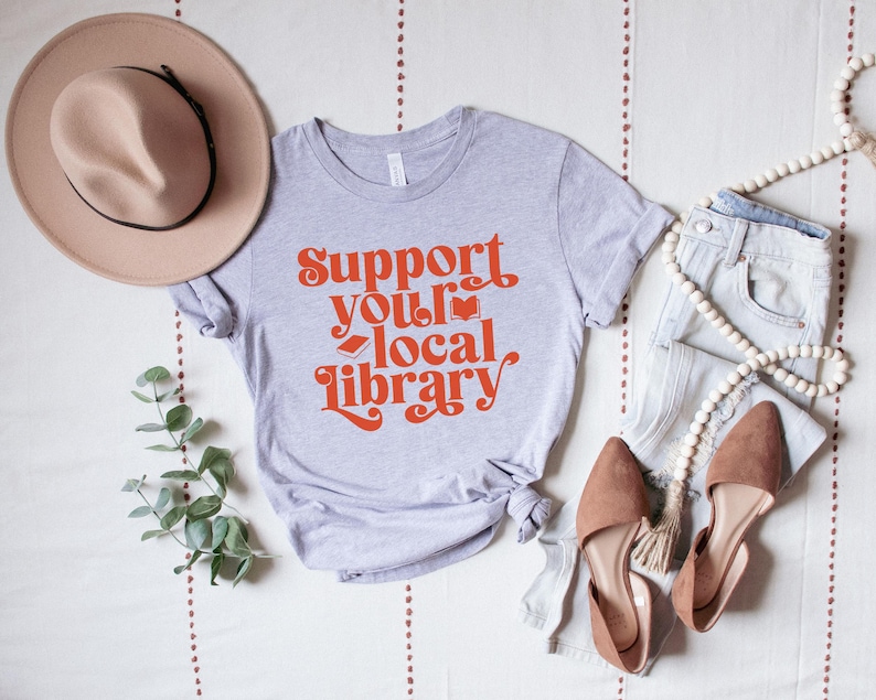 gray t shirt with red text support your local library