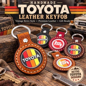 May include: A collection of round leather key fobs featuring the Toyota logo and colourful vertical stripes. The key fobs are crafted from textured brown, black, and red leather with silver metal rings and rivets, displaying various Toyota branding.