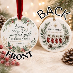 May include: Two round white ceramic ornaments. The left ornament features a red ribbon and the text Every GOOD AND perfect gift IS FROM ABOVE. JAMES 1:17 surrounded by holly and pine. The right ornament shows SMITH FAMILY with four stockings.