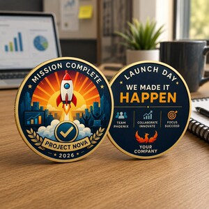 May include: Two circular commemorative coins with gold edges. The left coin features a rocket, city skyline, and text reading MISSION COMPLETE, PROJECT NOVA, 2026. The right coin displays LAUNCH DAY, WE MADE IT HAPPEN, TEAM PHOENIX, COLLABORATE INNOVATE, FOCUS SUCCEED, and YOUR COMPANY.