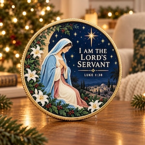 Peut inclure: Une plaque décorative circulaire avec un bord doré représentant une femme en robe bleue et blanche. Le texte indique I AM THE LORD'S SERVANT LUKE 1:38. La scène comprend des lys blancs, des baies rouges et un ciel nocturne étoilé.