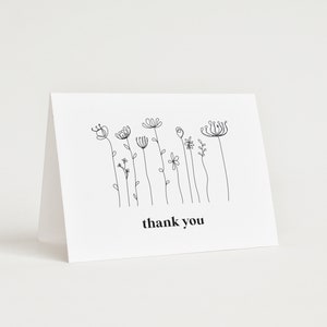 A minimalist wildflower 5x3.5 Landscape Baby Shower Thank You Card, consiting of bloack monoline flowers, and the text is in black. You can personalise your editable Thank You Card template in Corjl.