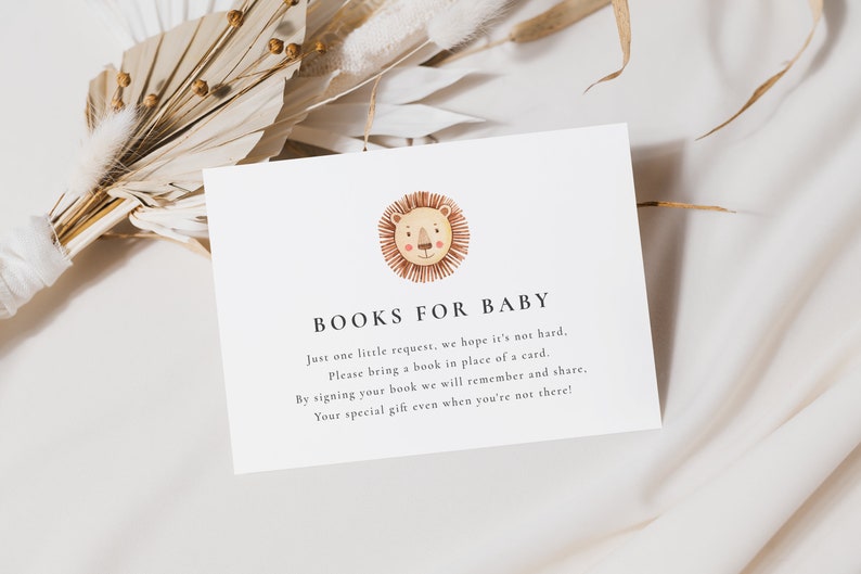 A minimalist 5x3.5 Baby Shower Books for Baby Card, with a watercolour boho lion face. The editable elegant dark grey text is personalisable in Corjl.