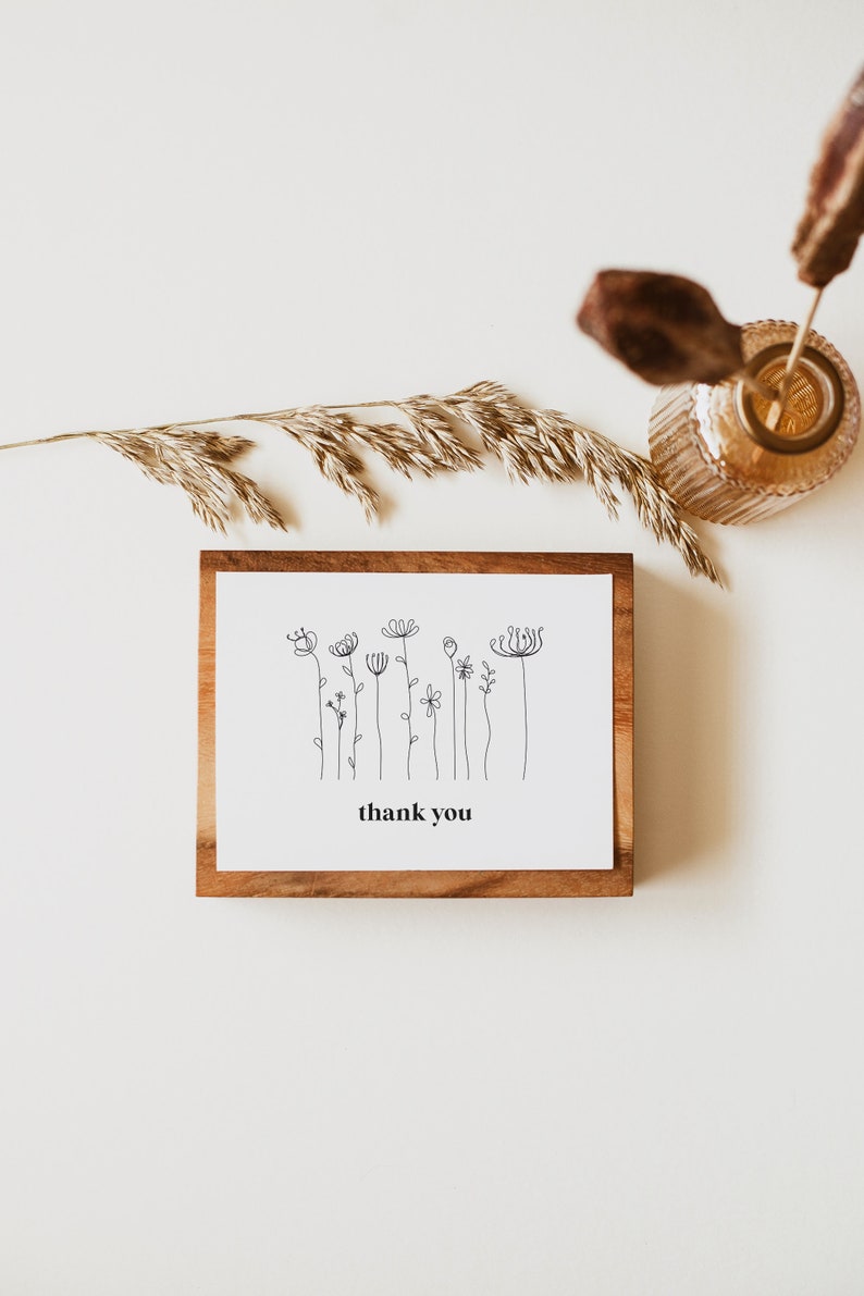 A minimalist wildflower 5x3.5 Landscape Baby Shower Thank You Card, consiting of bloack monoline flowers, and the text is in black. You can personalise your editable Thank You Card template in Corjl.