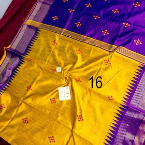 May include: A colourful textile in yellow and purple. The fabric has a repeating pattern of small, colourful floral designs. The number "16" is visible on the yellow section. The edges are trimmed with a decorative border.
