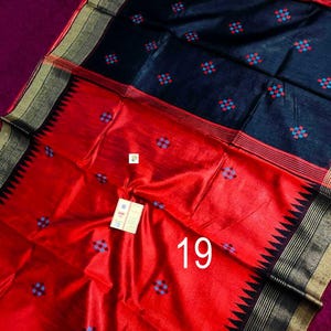 May include: A striking red and black textile with a geometric pattern. The fabric features a bold red section with a repeating blue and red square design. The black section also has the same pattern. The number "19" is visible on the red section.