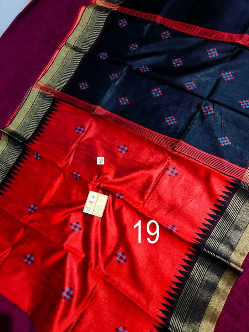 May include: A striking red and black textile with a geometric pattern. The fabric features a bold red section with a repeating blue and red square design. The black section also has the same pattern. The number "19" is visible on the red section.