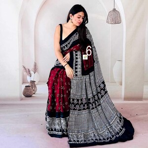 May include: A saree featuring a deep maroon section with small white floral patterns and a contrasting black section with intricate white geometric and botanical block print designs, including a wide border with detailed white motifs.