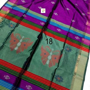 Puede incluir: Un sari morado y verde con un gran motivo de mariposa en el centro, peque&ntilde;os patrones blancos en forma de hoja y rayas horizontales en rojo, azul y verde. La tela muestra el n&uacute;mero 18 en negro y un peque&ntilde;o logotipo cuadrado.