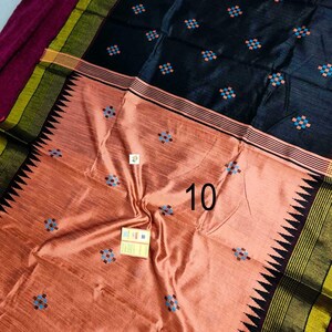 May include: A peach and black textile with a geometric pattern. The fabric features small, square designs in blue and orange. The border has a black, green, and yellow striped design with a zig-zag edge. The number "10" is visible on the fabric.