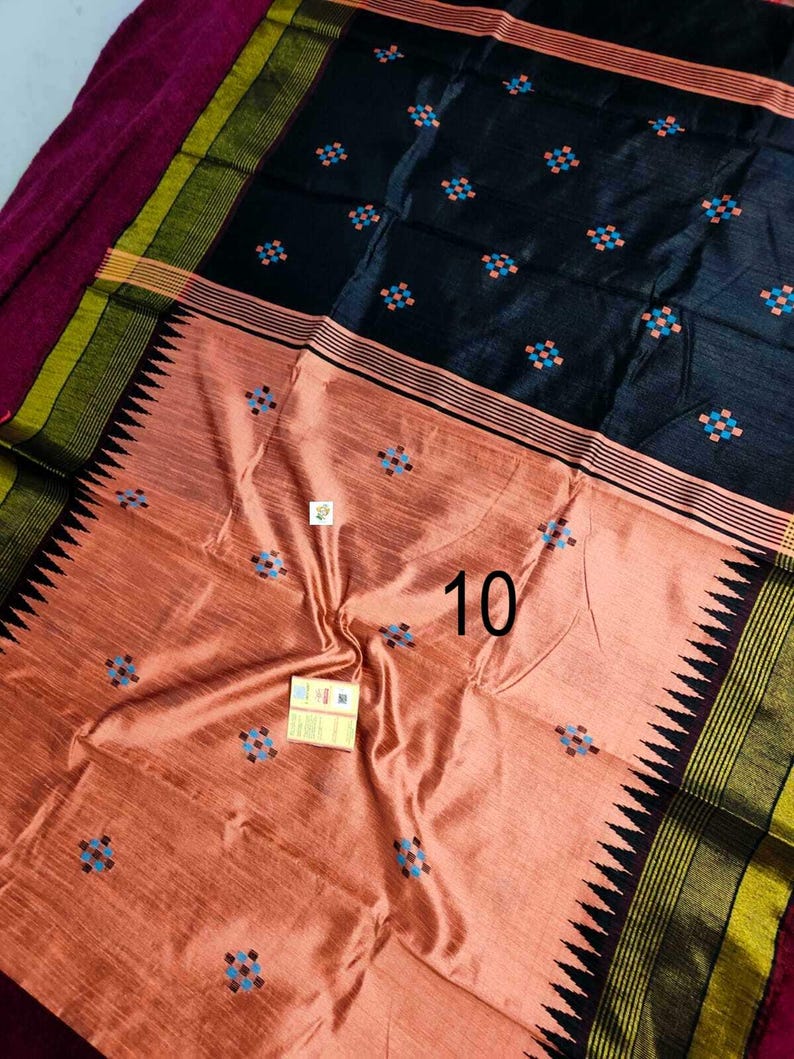 May include: A peach and black textile with a geometric pattern. The fabric features small, square designs in blue and orange. The border has a black, green, and yellow striped design with a zig-zag edge. The number "10" is visible on the fabric.