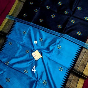 May include: A colourful textile with a dual-tone design. The upper section is a deep navy blue, decorated with small, repeating yellow and blue square patterns. The lower half is a bright turquoise, with a contrasting black and gold border. The number "4" is visible.