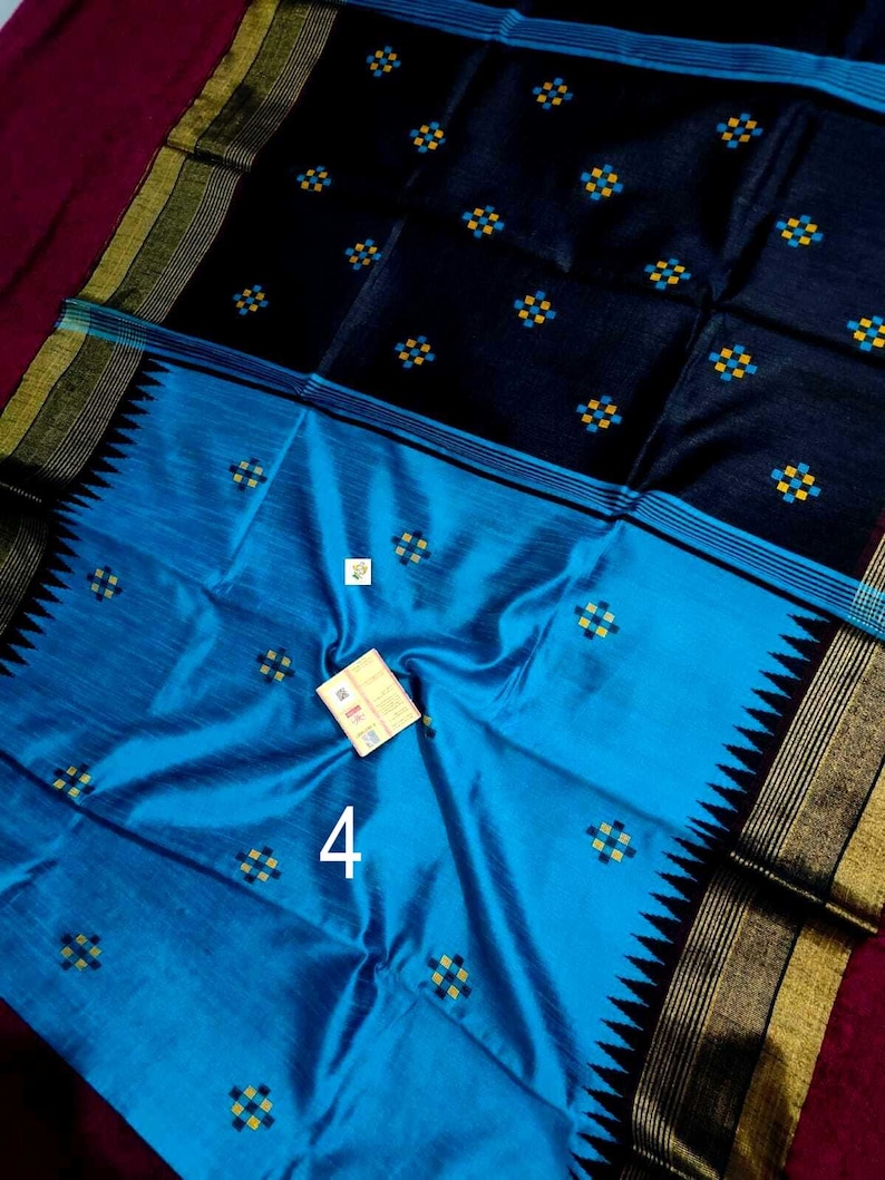 May include: A colourful textile with a dual-tone design. The upper section is a deep navy blue, decorated with small, repeating yellow and blue square patterns. The lower half is a bright turquoise, with a contrasting black and gold border. The number "4" is visible.