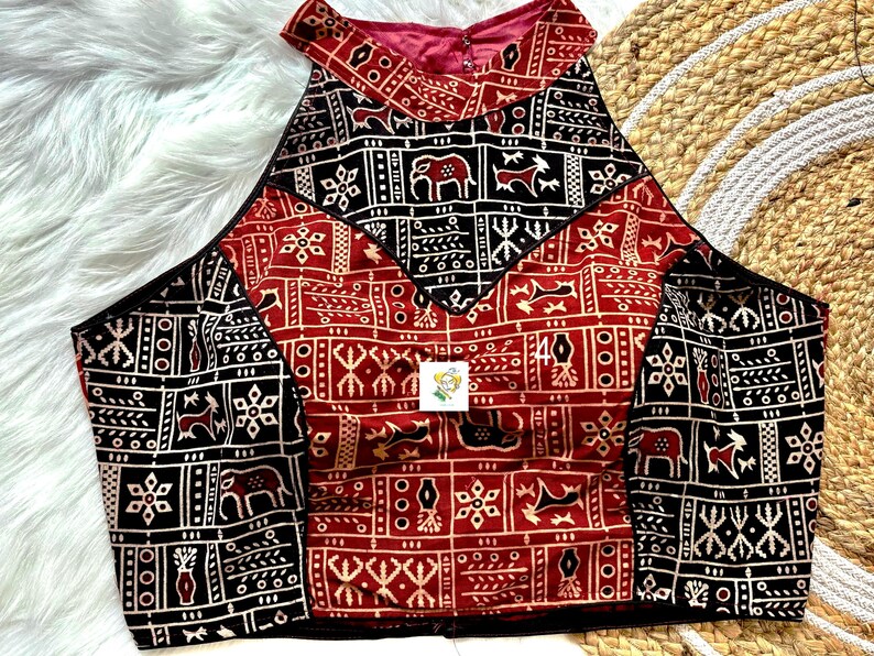 Puede incluir: Un top halter rojo y negro con cuello alto y dise&ntilde;o geom&eacute;trico. El top est&aacute; hecho de tela de algod&oacute;n y tiene una silueta ajustada.
