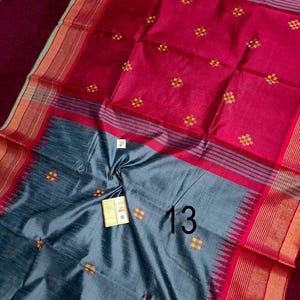 May include: A colourful textile with red and grey sections. The fabric is decorated with small, repeating floral patterns in yellow and orange. The number "13" is visible on the grey section. The edges have striped borders.