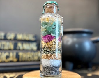 May include: A glass bottle filled with various herbs, crystals, and other ingredients. The bottle has a cork stopper and a green wax seal. The bottle is sitting on a wooden base.