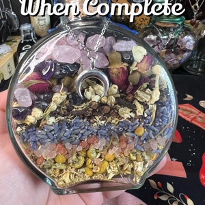 May include: A glass jar filled with dried flowers, herbs, crystals, and a silver crescent moon charm. The jar is labeled "When Complete".