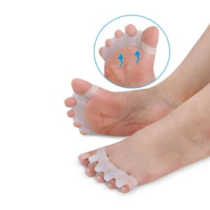 May include: White silicone toe separators designed to help align toes and reduce bunions. The separators are shown on a person's foot.