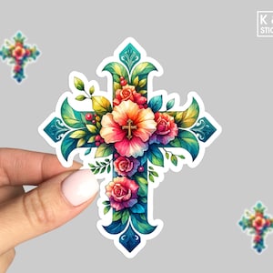 May include: A colorful floral cross sticker with a gold cross in the center. The cross is surrounded by pink, red, yellow, and white flowers with green leaves. The sticker is on a white background.