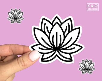 May include: Black and white outline sticker of a lotus flower. The sticker is on a pink background and is being held by a hand.