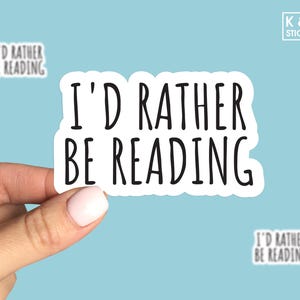 May include: White sticker with black text that reads "I'd rather be reading".