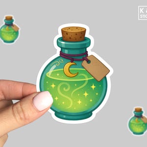 May include: A sticker featuring a teal potion bottle with a cork stopper, a gold crescent moon charm, and a blank tag. The bottle contains a glowing green liquid with stars and swirls. The sticker is held by a hand. The text "K & O STICKERS" is in the upper right corner.
