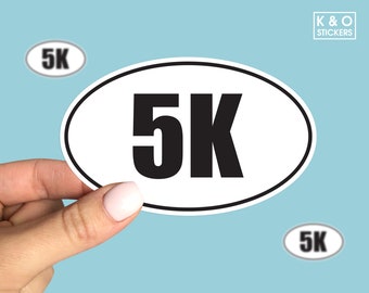 Könnte beinhalten: Weißer ovaler Aufkleber mit schwarzem Text "5K".