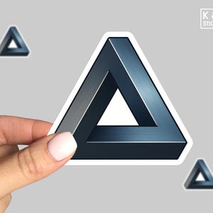 May include: A sticker featuring an impossible triangle illusion in shades of blue and gray. The sticker is held by a hand, with two additional smaller triangle stickers visible. The logo "K & O Stickers" is in the upper right corner.