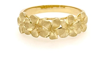 May include: A gold ring with a band of five plumeria flowers. The flowers are raised and have a textured finish.
