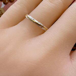 May include: A thin silver band with a delicate etched design.