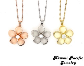 Puede incluir: Tres collares de oro con un colgante de flor de plumeria. Los colgantes son de oro rosa, plata y oro.